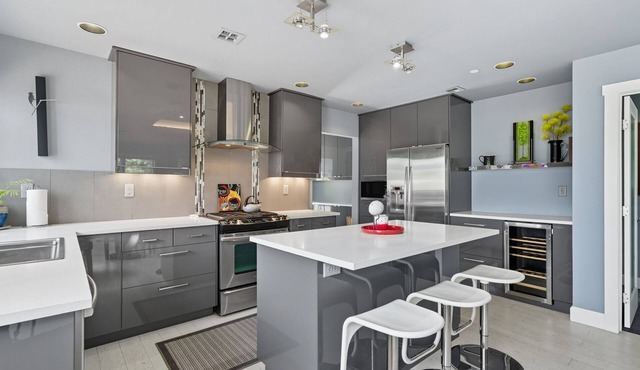Top-level duplex featuring a sleek open concept kitchen with stainless appliances, cozy fireplace, stylish furnishings, and in-unit washer/dryer. Designed for basking in the sun under skylights in thoughtful details throughout.